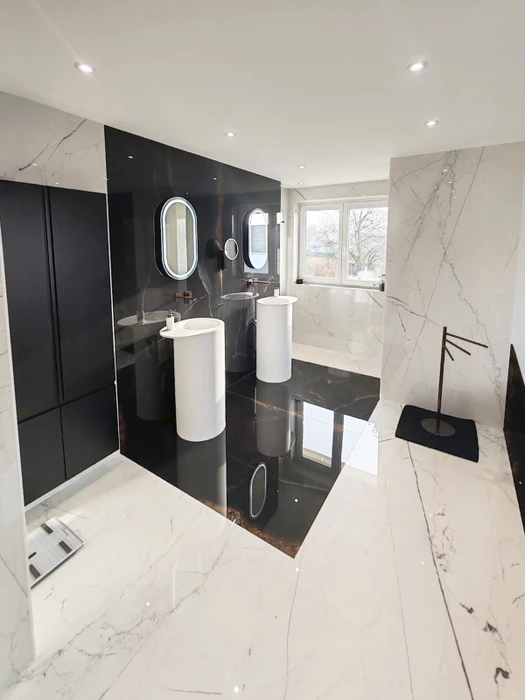 Salle de bain luxueuse moderne avec double vasque colonne autoportante blanche, carrelage grand format effet marbre blanc veiné et dalle noire polie
