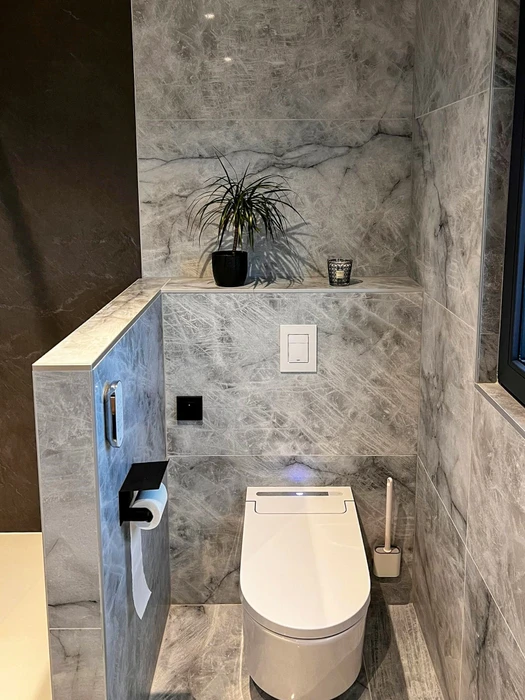 Toilette suspendue design blanc avec bidet intégré, installée dans un WC séparé haut de gamme