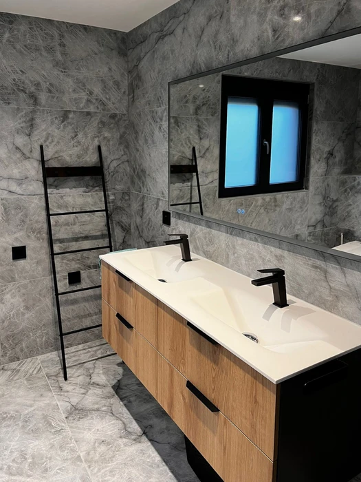 Salle de bains moderne avec double vasque encastrée blanche sur meuble suspendu en bois naturel avec tiroirs à poignées noires