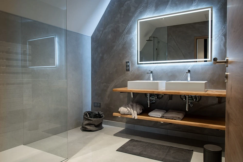 Salle de bain moderne avec douche à l'italienne en verre transparent, double vasque à poser rectangulaire blanche sur plan en chêne massif, miroir LED rétroéclairé