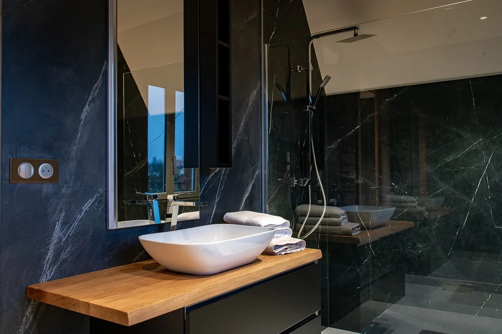 Salle de bain moderne avec douche à l'italienne en verre transparent, double vasque à poser rectangulaire blanche sur plan en chêne massif, miroir LED rétroéclairé