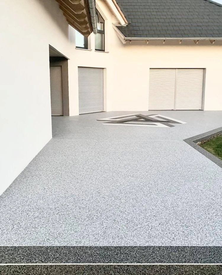 Façade extérieure d'une maison moderne avec soubassement en granulats de verre concassé gris-vert, texture rugueuse et irrégulière