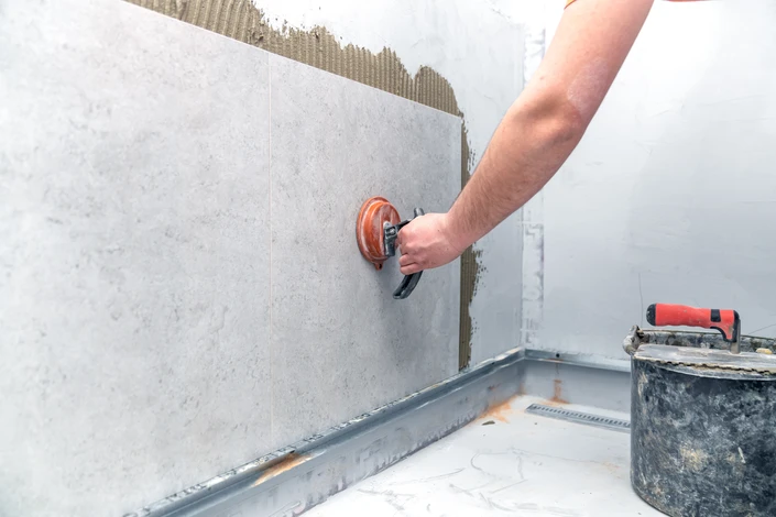 Carrelage en pierre naturelle grise posé en opus romain avec joints blancs sur sol intérieur