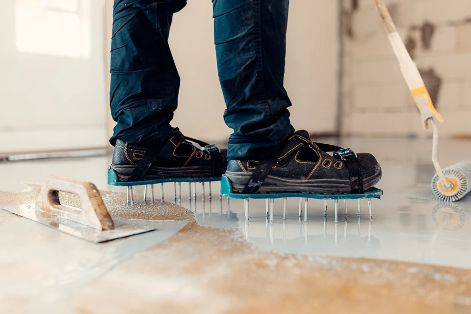 Gros plan professionnel montrant une main d'artisan appliquant une r&eacute;sine liquide d&eacute;corativeavec une spatule ou un outil sp&eacute;cialis&eacute; sur une surface, avec la r&eacute;sine formant un fini lisse et brillant r&eacute;v&eacute;lant des reflets ou un effet de couleur riche et moderne. La surface en arri&egrave;re-plan doit montrer le rendu fini impeccable, haut de gamme et distinctif d'une r&eacute;sine d&eacute;corative premium. Lumi&egrave;re naturelle ou professionnelle mettant en &eacute;vidence la qualit&eacute; et l'aspect haut de gamme du produit appliqu&eacute;.